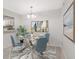 Elegant dining room with glass table and four blue chairs, and view into kitchen at 1302 Woodcliff Dr, Atlanta, GA 30350