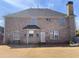 Exterior view of the brick home's backyard and a partial view of a fenced yard at 1251 Marlton Chase Dr, Lawrenceville, GA 30044