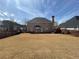 Backyard with a view of the rear of the home; note the brick and chimney at 1251 Marlton Chase Dr, Lawrenceville, GA 30044