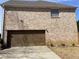 Brick exterior highlighting the two-car garage and partial view of the side yard at 1251 Marlton Chase Dr, Lawrenceville, GA 30044