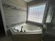 Close-up of soaking tub with dark fixtures at 1251 Marlton Chase Dr, Lawrenceville, GA 30044