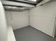 Empty unfinished basement room with a painted concrete floor and white walls at 2071 Carthage Rd, Tucker, GA 30084