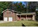 Classic brick home showcasing red shutters, a front porch, and an attached two-car garage at 2071 Carthage Rd, Tucker, GA 30084