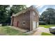 Rear view of brick home showing the yard and an attached two-car garage at 2071 Carthage Rd, Tucker, GA 30084