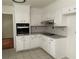 Updated kitchen featuring white cabinets, granite countertops, tile backsplash and stainless oven at 2071 Carthage Rd, Tucker, GA 30084