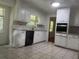 Charming kitchen features white cabinets, tiled floors, and natural light at 2071 Carthage Rd, Tucker, GA 30084