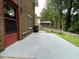 Concrete patio adjacent to the house, surrounded by a lush green yard and mature trees at 2071 Carthage Rd, Tucker, GA 30084