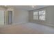 Spacious bedroom with neutral walls and carpet, featuring multiple windows and a private door at 4037 Andover Cir, Mcdonough, GA 30252