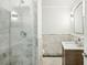 Modern bathroom featuring marble tile, glass shower, and floating wood vanity at 952 Lindbergh Ne Dr, Atlanta, GA 30324