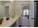 Bright bathroom featuring a long vanity with double sinks and a doorway leading to the Primary bedroom at 108 Laurel Bay Se Dr, Loganville, GA 30052
