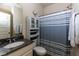 Bathroom with a granite countertop vanity, shower with striped curtain and built-in cabinet at 108 Laurel Bay Se Dr, Loganville, GA 30052