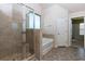 Primary bathroom featuring tiled walk-in shower and a separate soaking tub with a window at 108 Laurel Bay Se Dr, Loganville, GA 30052