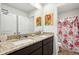 Bathroom featuring granite countertop vanity with dual sinks and a shower with patterned curtains at 1363 Midnight Ride Ct, Hampton, GA 30228