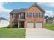 Beautiful two-story brick home featuring an attached two-car garage and a well-manicured lawn at 1363 Midnight Ride Ct, Hampton, GA 30228