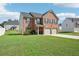 Lovely brick two-story home featuring a two-car garage and a lush green lawn at 1363 Midnight Ride Ct, Hampton, GA 30228