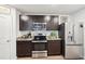 Kitchen featuring stainless steel appliances, dark brown cabinetry, and granite countertops at 1363 Midnight Ride Ct, Hampton, GA 30228