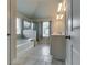 Bright bathroom features tiled floors, a separate shower, and soaking tub with a window at 7214 Gladstone Cir, Stonecrest, GA 30038