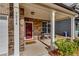 Inviting front porch with brick columns, seating and a bright red door at 7214 Gladstone Cir, Stonecrest, GA 30038