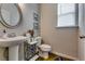 Cozy powder room with pedestal sink, decorative mirror, and natural light from a window at 7214 Gladstone Cir, Stonecrest, GA 30038