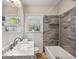 Bathroom features a modern sink and vanity, a combo tub/shower, and a window at 2627 Elsinore St, East Point, GA 30344