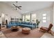 Cozy living room featuring a large blue sectional sofa, ceiling fan, and ample natural light at 2627 Elsinore St, East Point, GA 30344