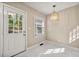 Bright mud room with modern light fixture, window, and door with window panes and marble tile floors at 2627 Elsinore St, East Point, GA 30344
