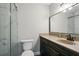 Bathroom featuring a modern vanity with stone countertops, framed mirror, and walk in shower with marble tiling at 5566 Kingsport Dr, Atlanta, GA 30342