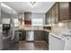 Modern kitchen features stainless steel appliances, granite countertops, and dark wood cabinets at 5566 Kingsport Dr, Atlanta, GA 30342