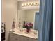 Double sink vanity with a large mirror, ample lighting, and fresh flowers at 5821 Saint Miles Dr, Buford, GA 30518