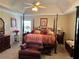 Bedroom featuring a four-poster bed, tray ceiling, an accent chair, and natural light from the window at 5821 Saint Miles Dr, Buford, GA 30518