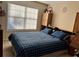 Bedroom featuring a bed with blue plaid covers, a window with blinds, and warm beige walls at 5821 Saint Miles Dr, Buford, GA 30518