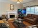 Comfortable living room with a fireplace, hardwood floors, and leather sofas at 5821 Saint Miles Dr, Buford, GA 30518