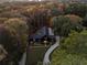 Aerial view of property showcasing modern home surrounded by lush forest in the fall at 2716 Ridgewood Nw Rd, Atlanta, GA 30327
