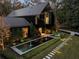 Striking contemporary home with black siding, a metal roof, water feature, and manicured landscaping at 2716 Ridgewood Nw Rd, Atlanta, GA 30327