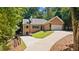Beautiful brick home with a well-maintained lawn, set amongst mature trees, on a sunny day at 7802 Bamby Rd, Cumming, GA 30041