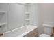 Clean bathroom with bathtub, toilet, and shelving at 606 Somerset Ct, Loganville, GA 30052