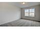 Spacious bedroom featuring grey carpet and a large window with a neighborhood view at 606 Somerset Ct, Loganville, GA 30052