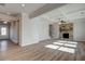 Open living room with hardwood floors, fireplace, and coffered ceiling at 606 Somerset Ct, Loganville, GA 30052