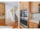 Kitchen features stainless steel double ovens and wood cabinets at 3830 High Point Cir, Cumming, GA 30041