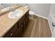 Bathroom featuring a granite-look vanity, toilet, and wood-look flooring at 3279 Wild Basil Ln, Buford, GA 30519
