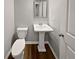 A traditional bathroom with a white pedestal sink, toilet and wood-look floors at 3279 Wild Basil Ln, Buford, GA 30519