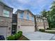 Charming townhome featuring a brick facade, a two-car garage, and a well-maintained lawn at 3279 Wild Basil Ln, Buford, GA 30519