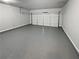 Spacious garage with gray epoxy flooring and a white door, ready for vehicles and projects at 3279 Wild Basil Ln, Buford, GA 30519