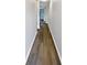 Long hallway with gray walls and wood-look flooring leads to a bright window at 3279 Wild Basil Ln, Buford, GA 30519