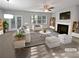 Bright living room with fireplace, ceiling fan, and french doors leading to backyard at 3279 Wild Basil Ln, Buford, GA 30519