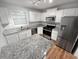 Well-lit kitchen with white cabinets, granite countertops, stainless steel appliances, and hardwood floors at 504 Vicksburg Pl, Atlanta, GA 30350