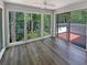 Bright sunroom with hardwood floors and large windows offering serene views of the surrounding trees at 504 Vicksburg Pl, Atlanta, GA 30350