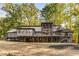 Back exterior showcasing multilevel home with large deck and lake view at 8316 Hewlett Rd, Sandy Springs, GA 30350