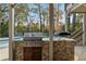 Outdoor kitchen with grill and pizza oven, adjacent to pool at 443 Wimbledon Ne Rd, Atlanta, GA 30324