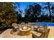 Fire pit and seating area overlooking the pool at night at 443 Wimbledon Ne Rd, Atlanta, GA 30324